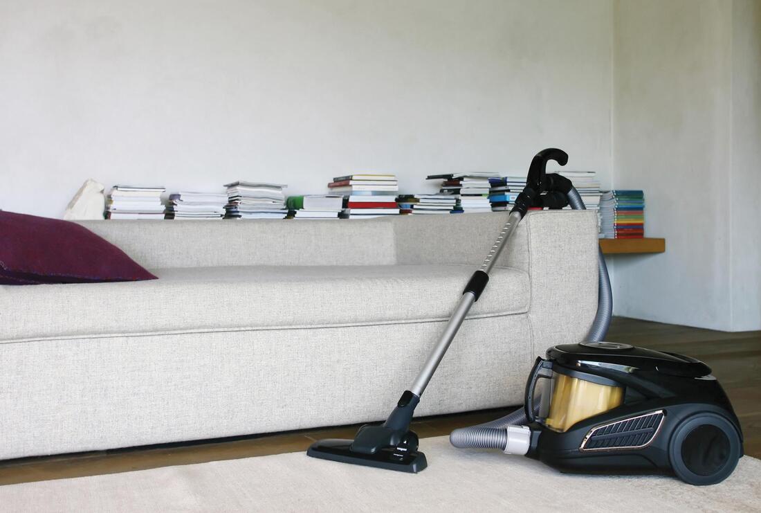 vacuum cleaner beside the sofa